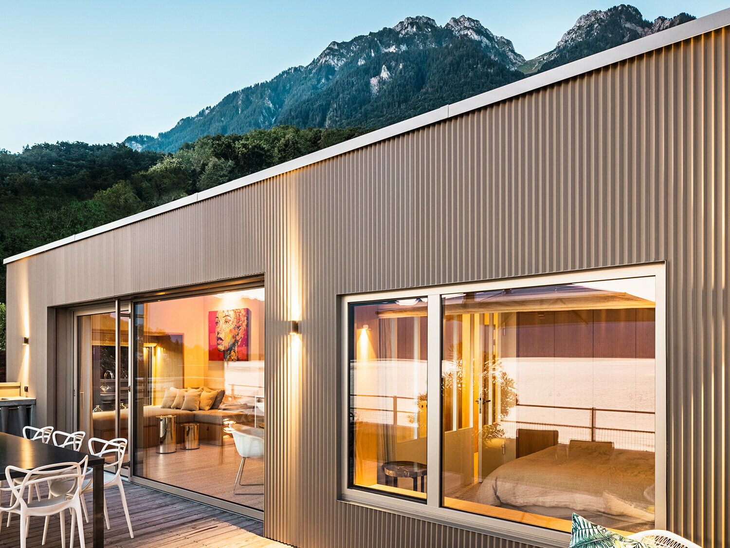 Pogled na terasu i deo unutrašnjosti zgrade uveče.