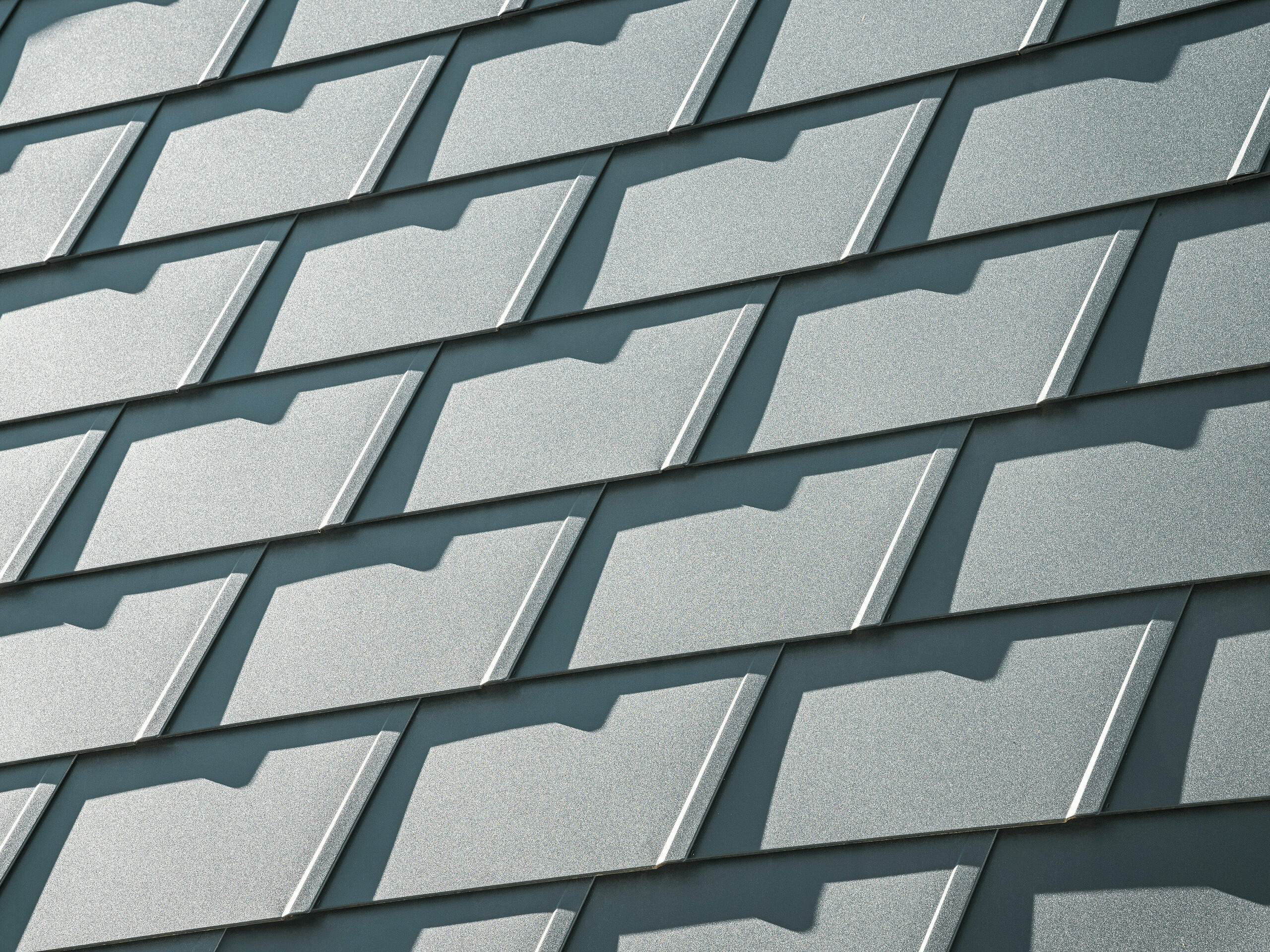 Detailansicht der PREFA Dachschindeln DS.19 in P.10 Anthrazit auf einem Einfamilienhaus in Mechernich. Die langlebigen Dachschindeln aus Aluminium bieten optimalen Schutz vor Witterungseinflüssen und sorgen für eine moderne, ästhetische Dachgestaltung.