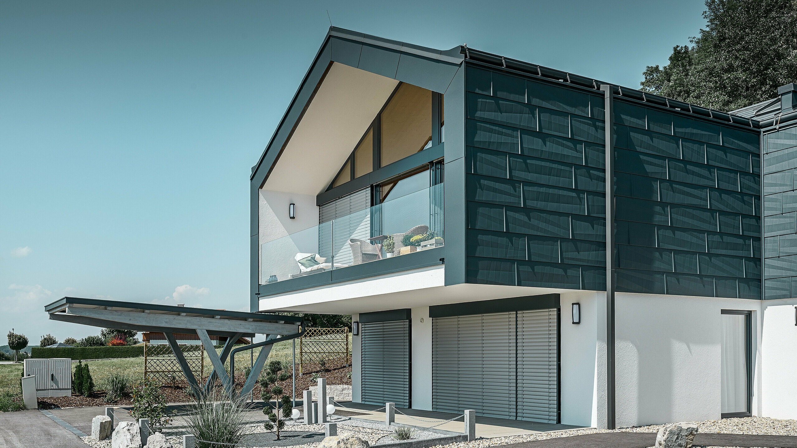 Obloga fasade gornjeg sprata sa PREFA fasadnim panelom FX.12 u P.10 antracit boji. Za odvođenje vode koristi se robustna četvrtasta olučna cev.