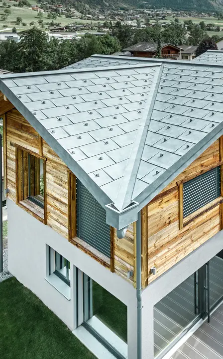 Švajcarski planinski dom sa PREFA aluminijumskim krovom. Položena je PREFA krovna ploča R.16 u kamen sivoj boji. Na gornjem spratu postavljena je rustična drvena fasada.