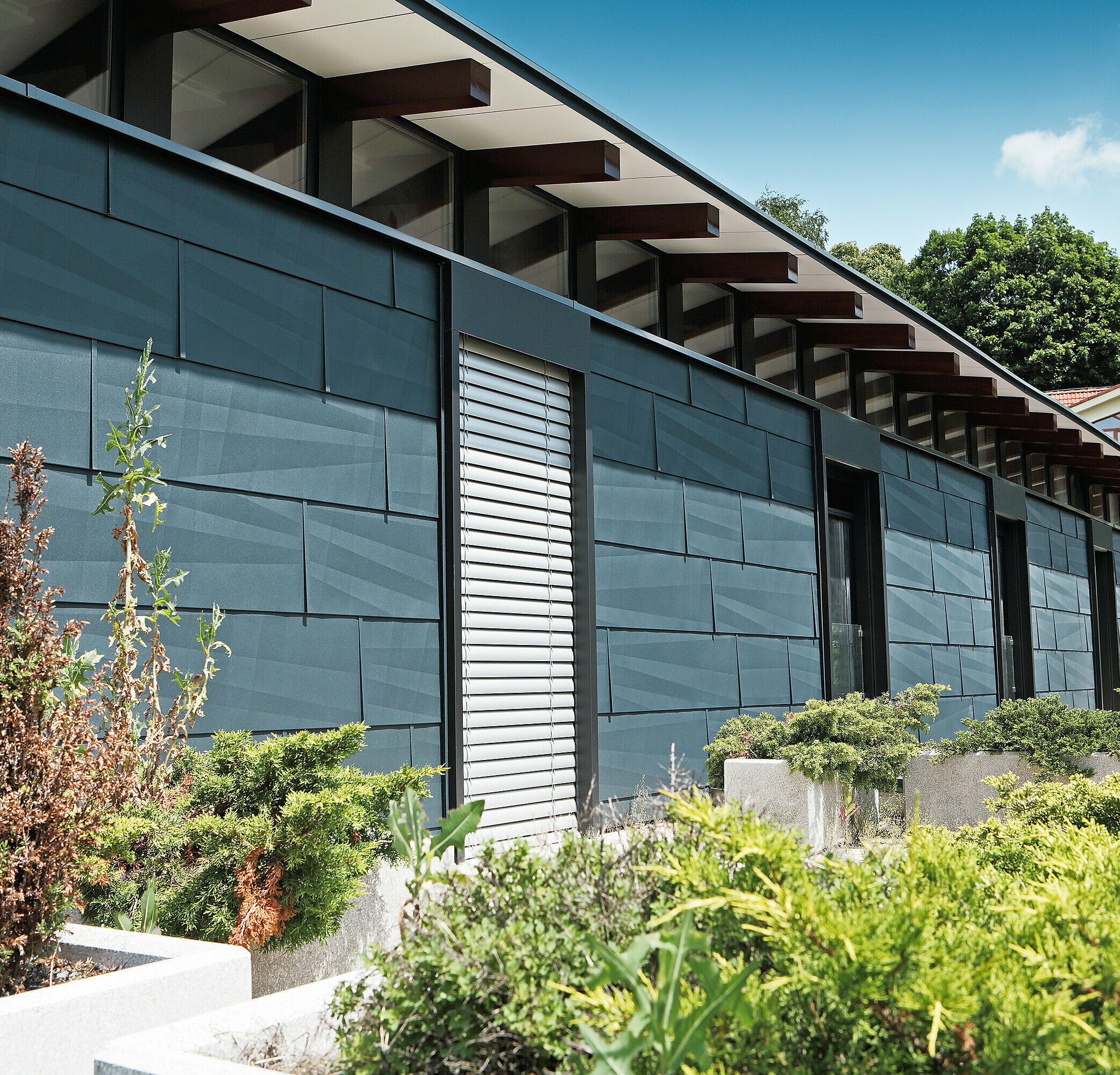 Moderne Wetterseite gestaltet mit dem Fassadenpaneel FX.12 in Anthrazit mit Garten.