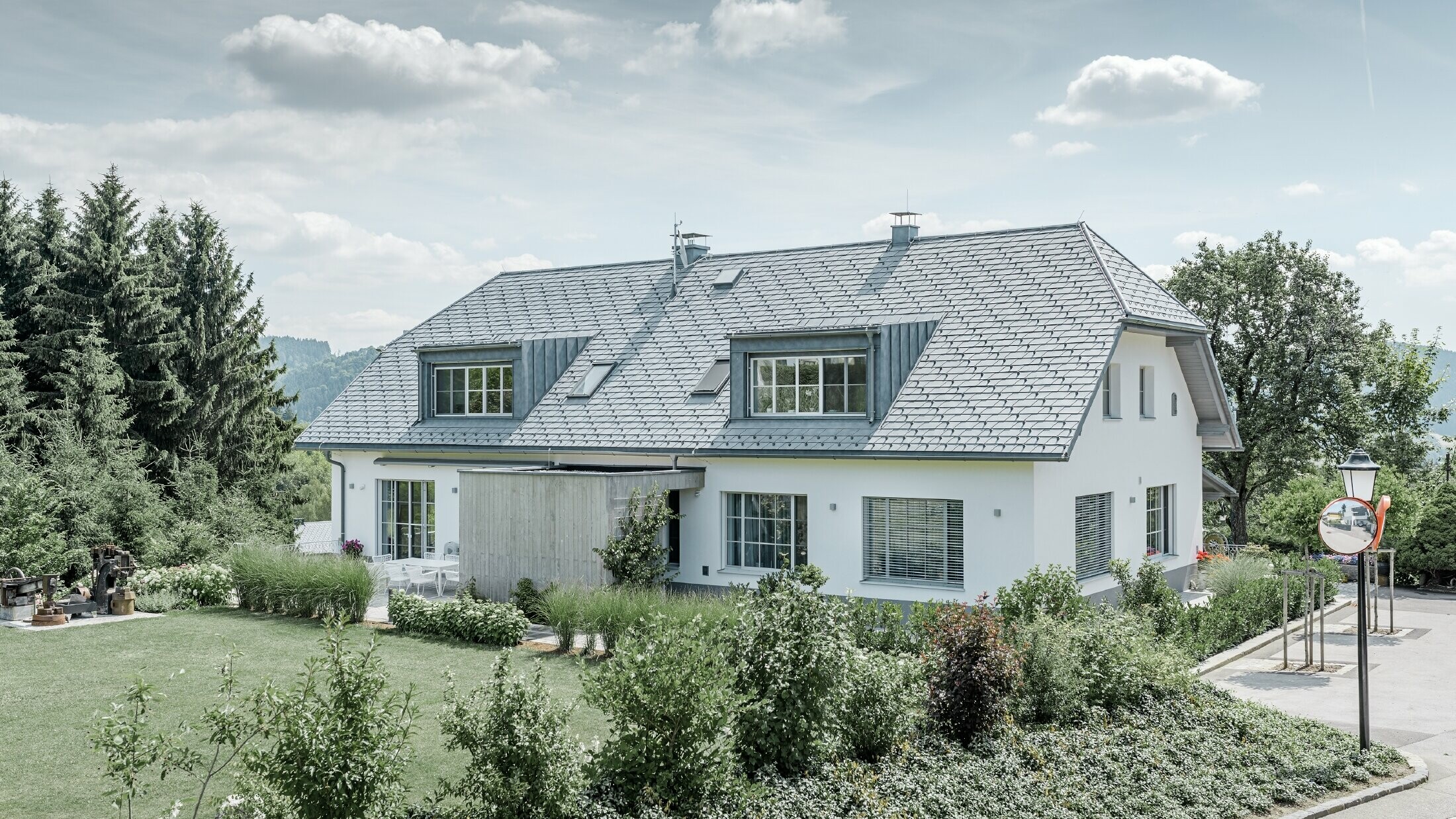 Gaube des neu sanierten Einfamilienhauses mit der PREFA Dachschindel in Steingrau. Die Gaube ist mit Prefalz (Stehfalz) verkleidet.