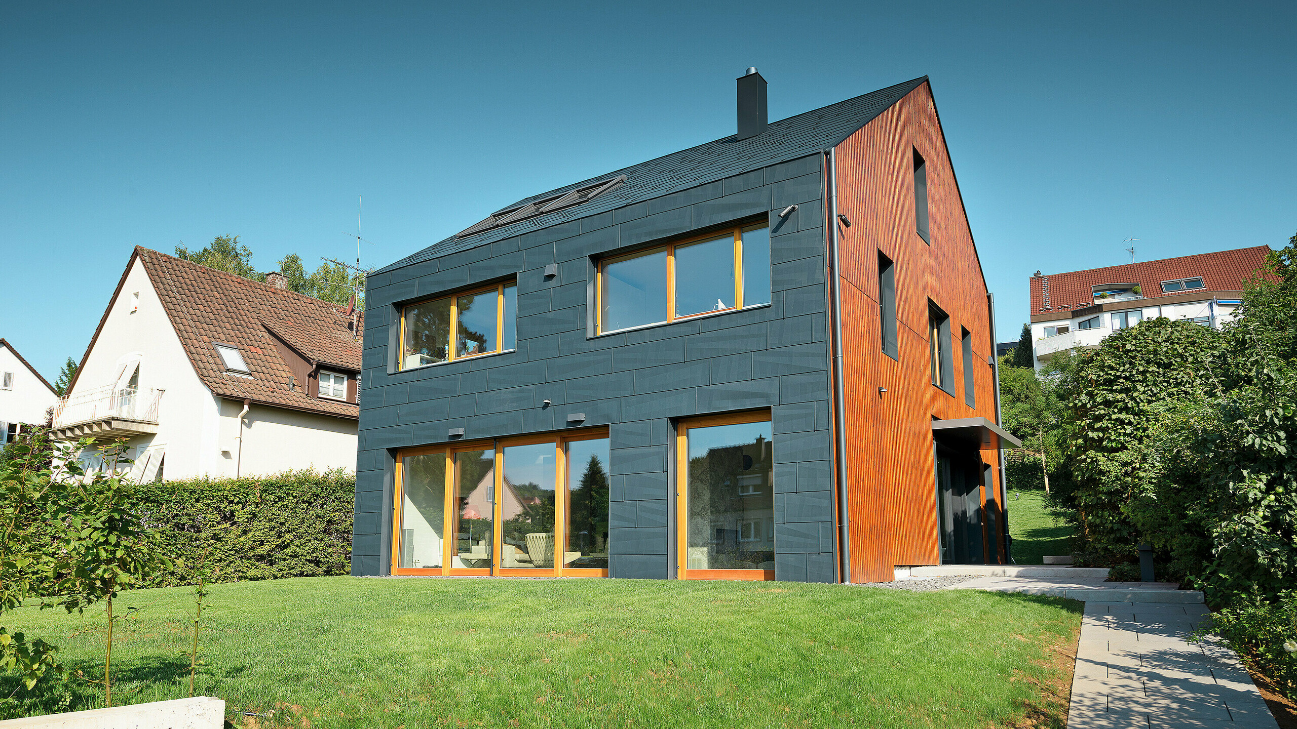 PREFA FX.12 fasada u P.10 antracit boji proteže se od fasade preko dvovodnog krova, potpuno bez strehe.