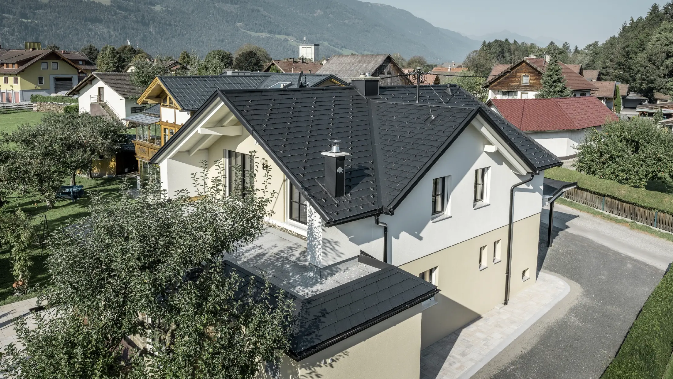 Traditionelles Einfamilienhaus mit Satteldach und großer Gaube, frisch saniert. Das Dach ist mit schwarzen Dachschindeln von PREFA eingedeckt.