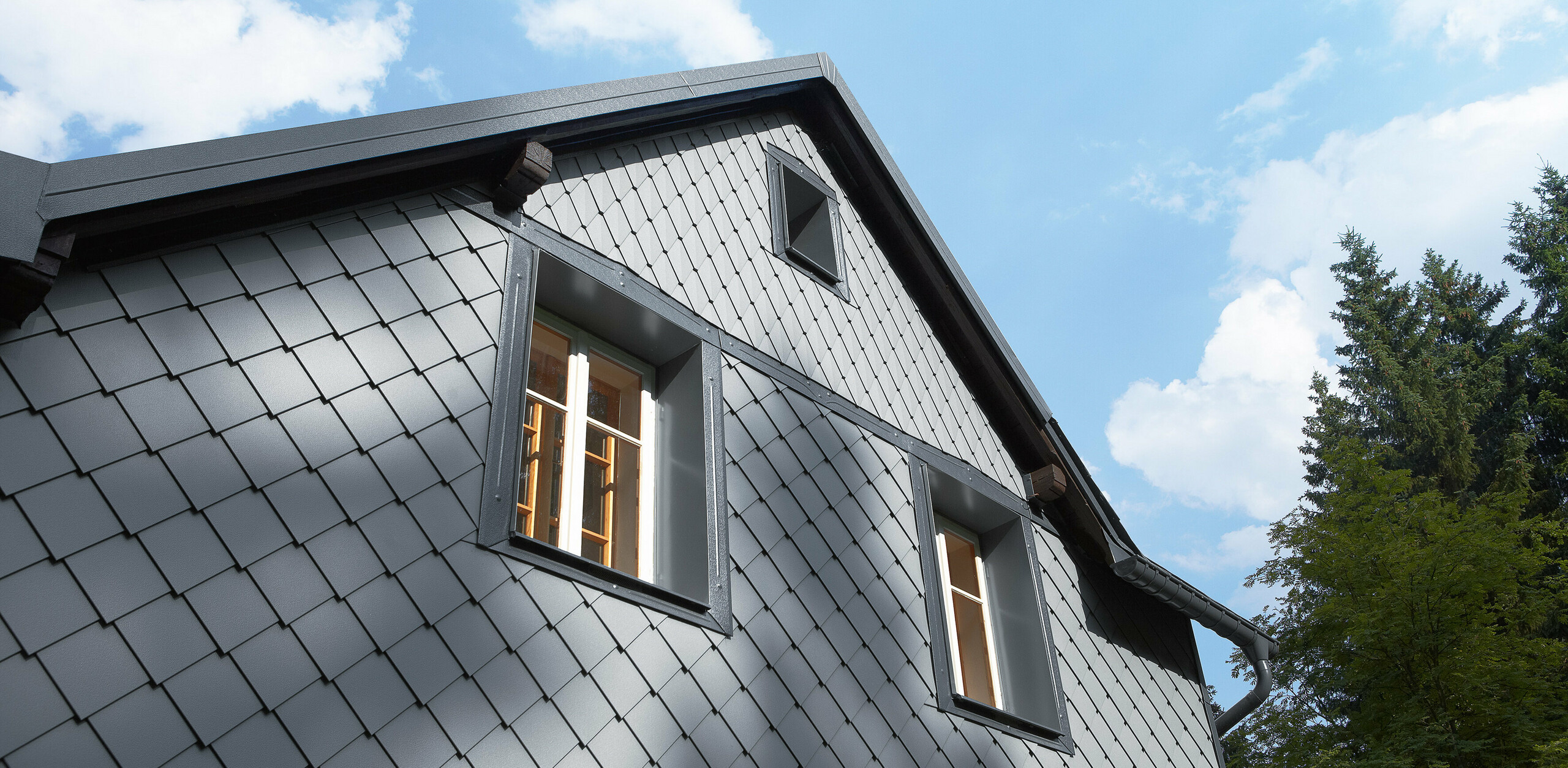 Wetterseite verkleidet mit der Wandraute 20 × 20 und der kleinen Raute an der Fassade von PREFA