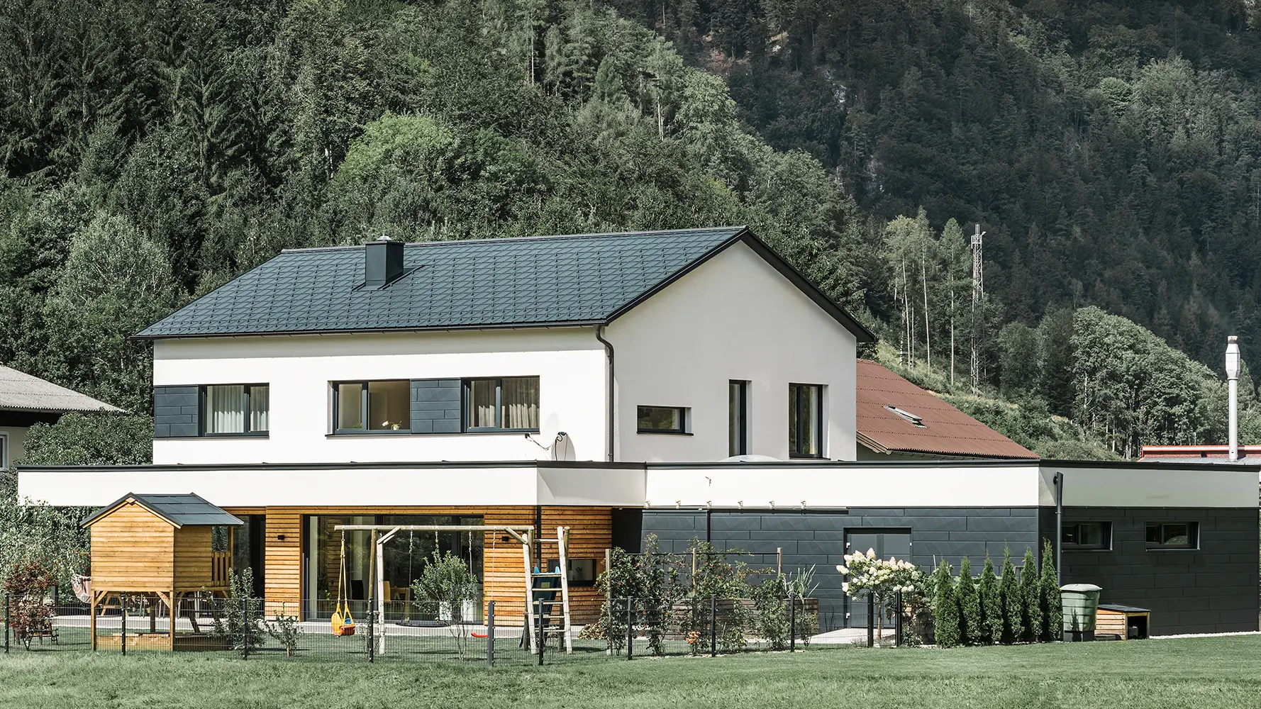 Nova porodična kuća sa fasadom od arišovog drveta u kombinaciji sa PREFA Siding.X fasadnom kasetom u antracit boji.