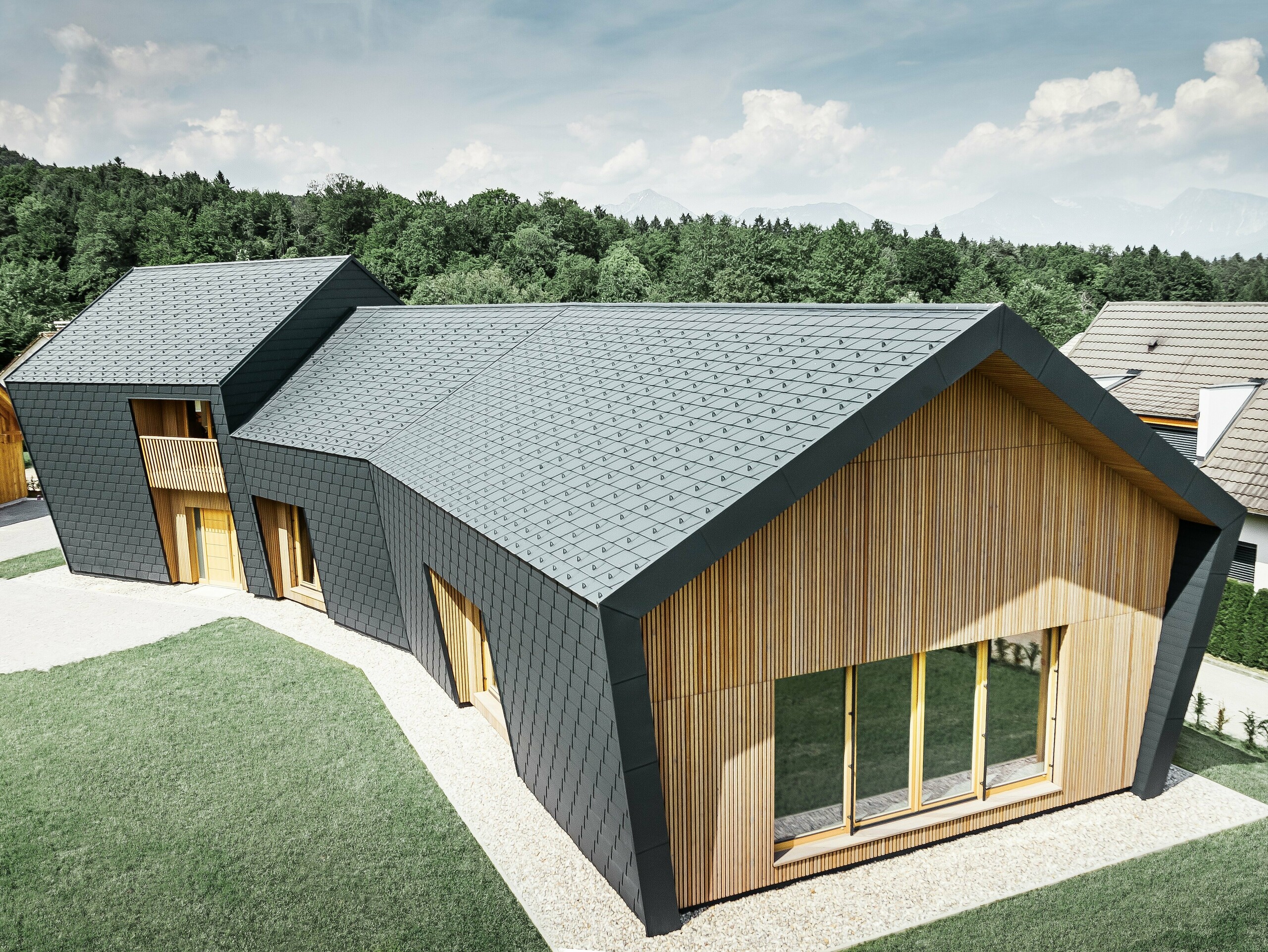 Dach und Fassade der Kletterhalle mit Dachschindel DS.19 in Anthrazit Große Dach- und Fassadenflächen, eingedeckt mit der Dachschindel DS.19 in P.10 Anthrazit, an der Stirnseite wurde die Fassade mit Holz verkleidet