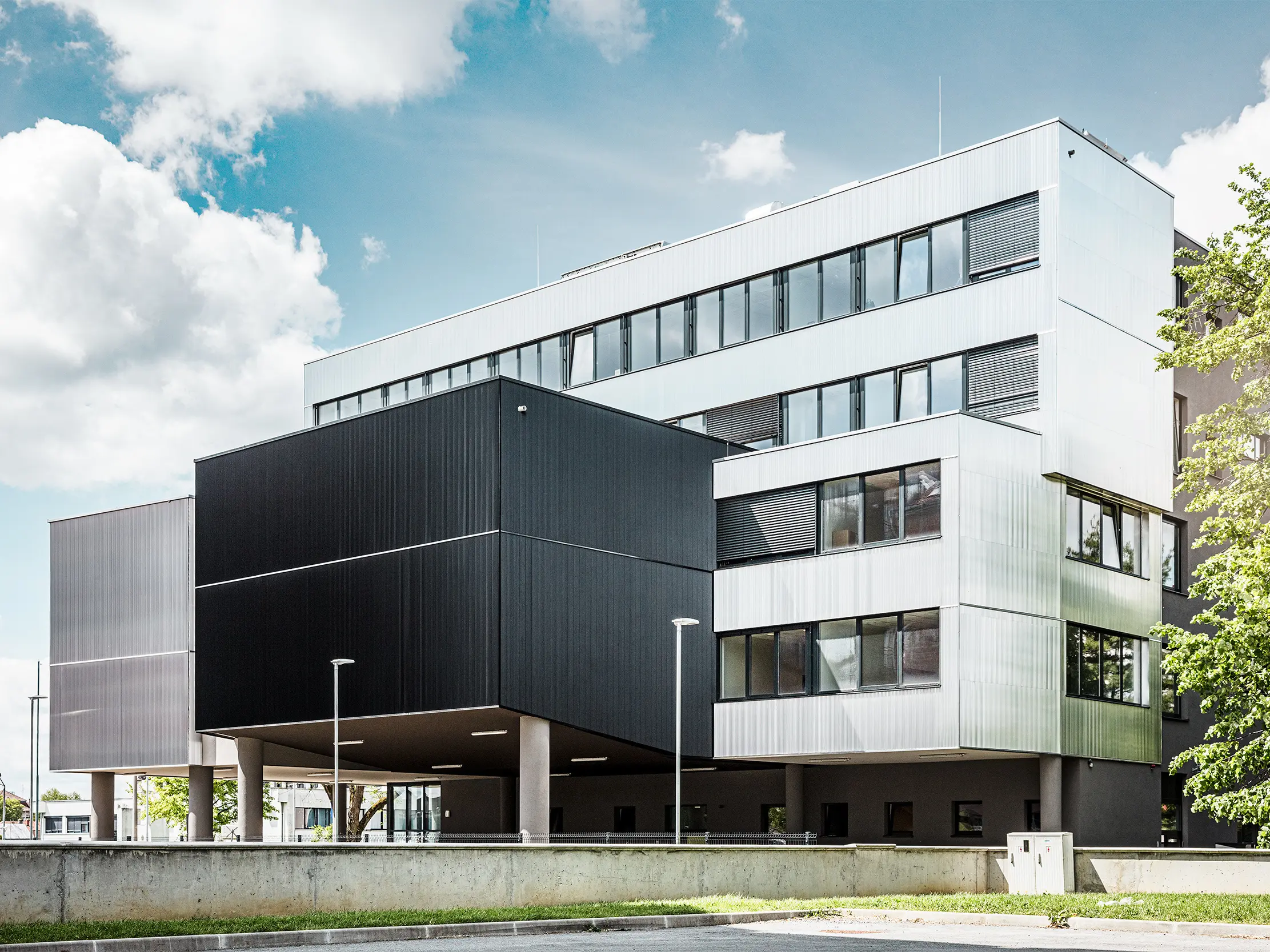 Bočni pogled na muzičku školu u Bjelovaru sa modernom PREFA fasadom sa zupčastim profilom. Fasada je izvedena u crnoj i natur aluminijum boji, a geometrijski oblici stvaraju upečatljiv, minimalistički dizajn.