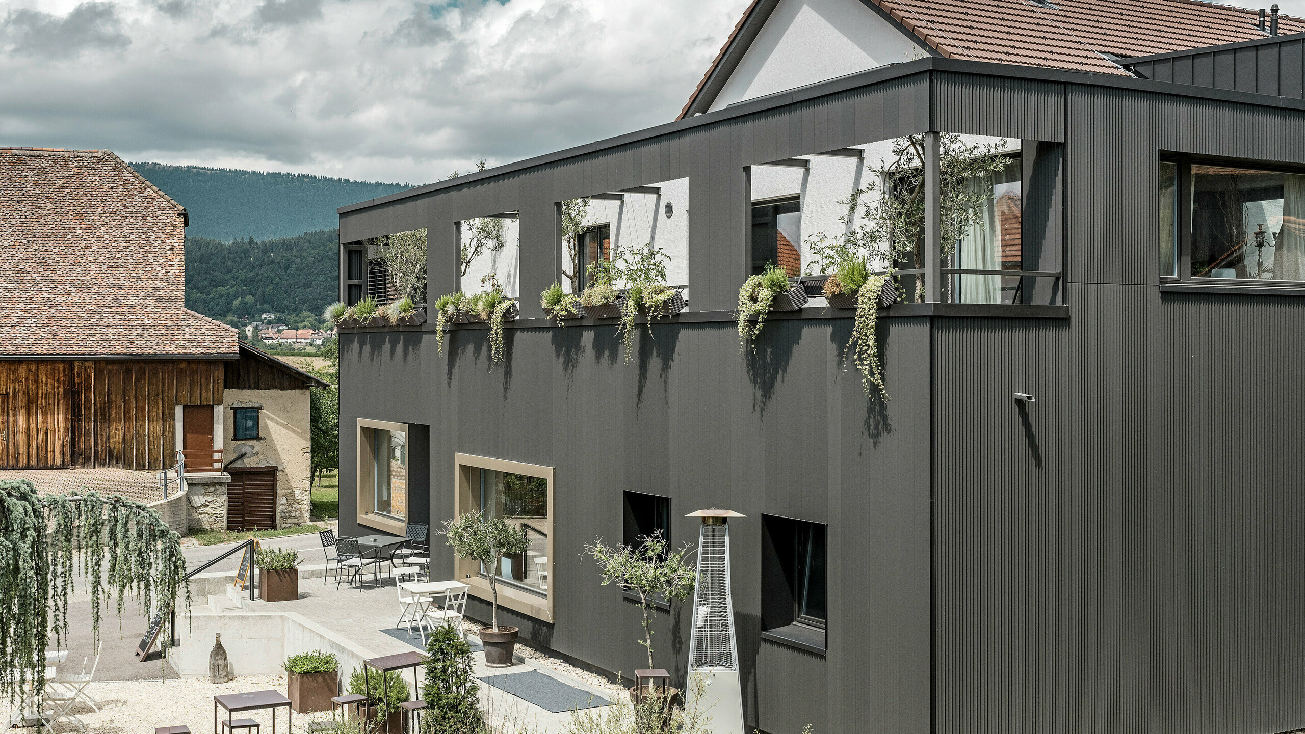 PREFA Zackenprofil in der Sonderfarbe Schwarzgrau auf dem Hôtel de l’Ours in Prêles, Schweiz