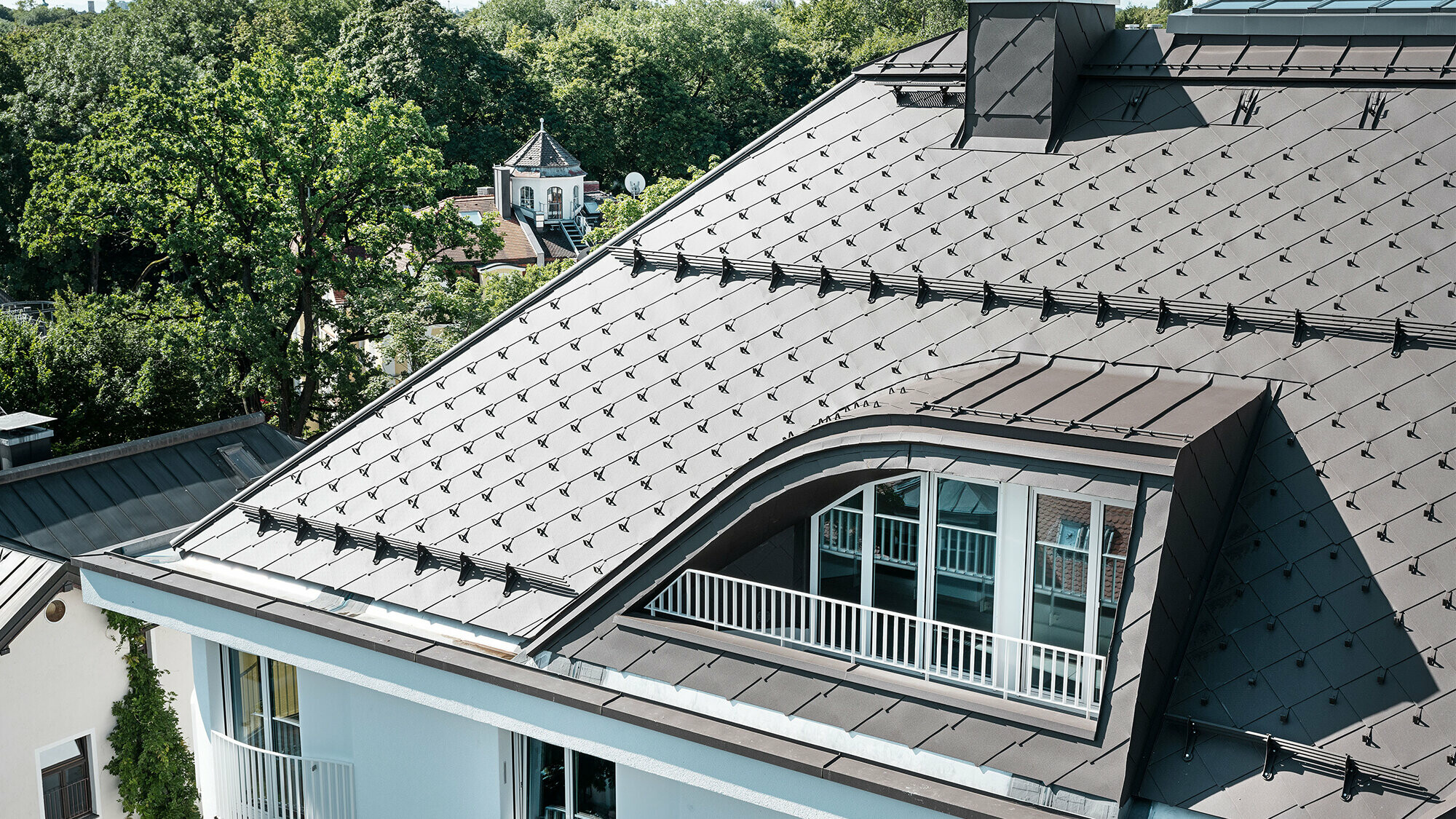 Mehrparteienhaus in München mit PREFA Dachraute 44 × 44 in Braun Mehrfamilienhaus mit Dachraute 44 × 44 von PREFA in Braun mit Schneestoppern und Schneerechen
