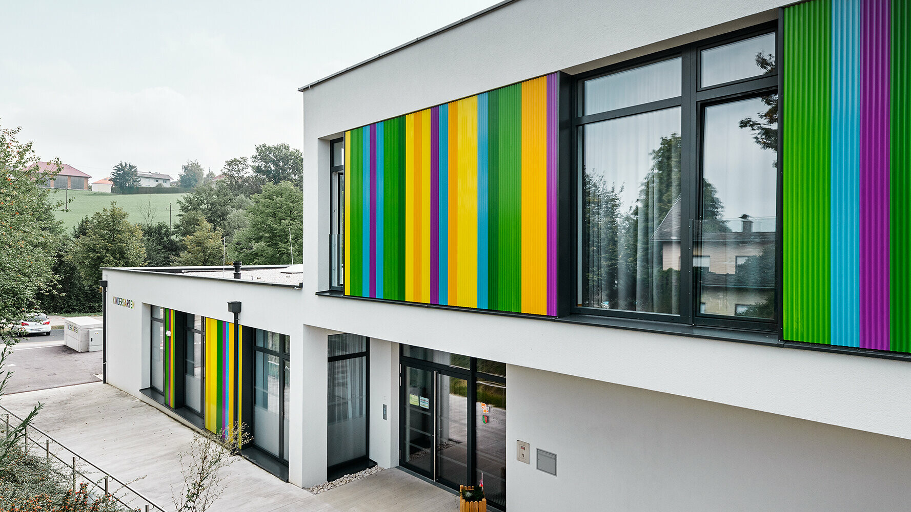 Kindergarten mit buntem PREFA Zackenprofil in Kombination mit einer Putzfassade