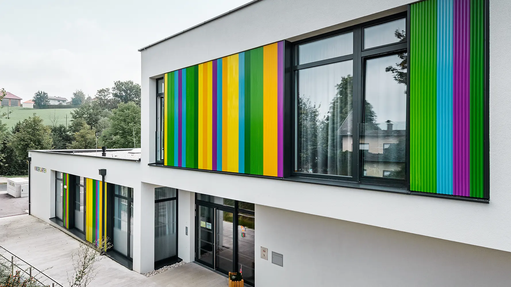 Kindergarten mit buntem PREFA Zackenprofil in Kombination mit einer Putzfassade